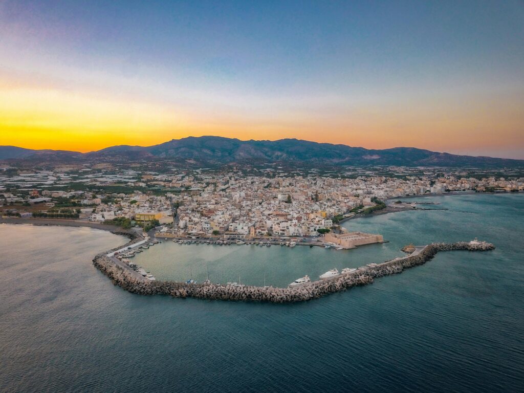 [Image: aerial view of Crete coastline with mountains and turquoise water — search "Crete Greece aerial" on Unsplash] Alt text: aerial view of Crete Greece coastline - best Greek island for first-timers